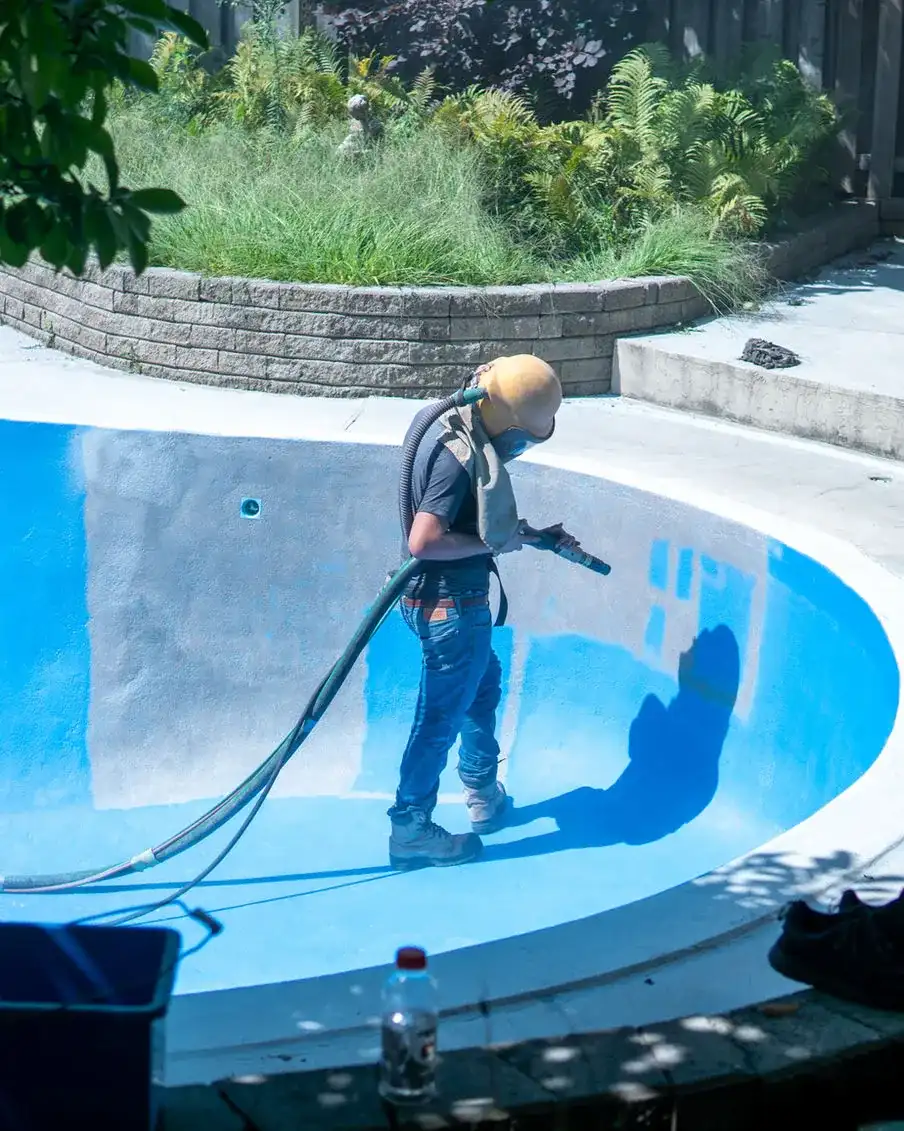 Pure Blast Solutions technician media blasting a commercial pool
